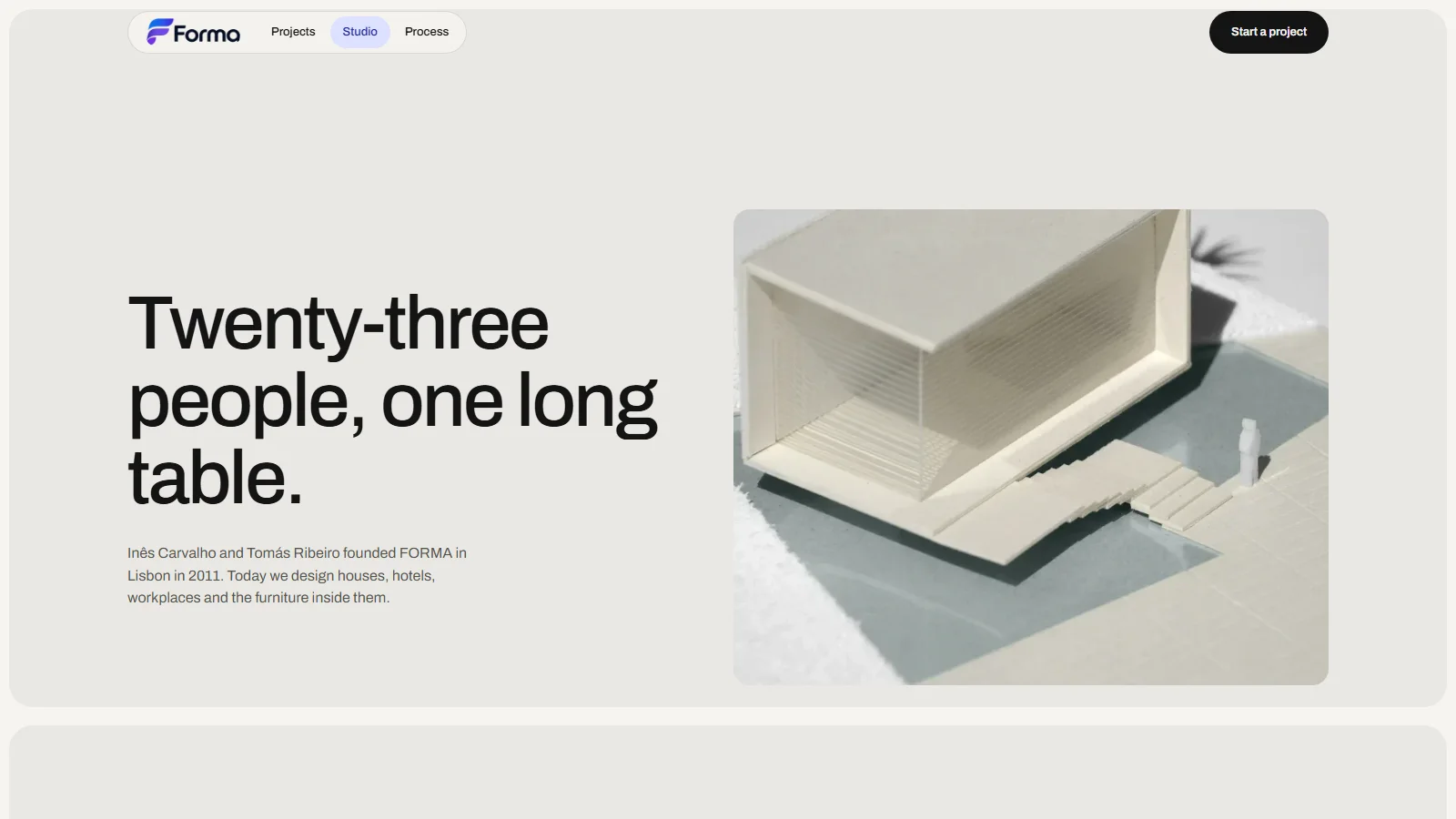 The Studio page, headed "Twenty-three people, one long table." beside a photograph of a cardboard study model of a pavilion over a pool